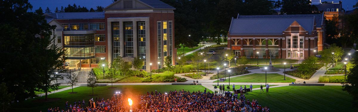 aerial view of uconn students outside in front of campus buildings during the night